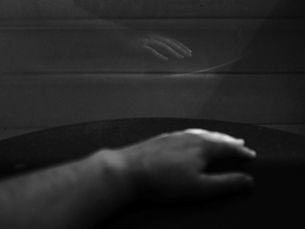 a black and white image of a hand reflected back