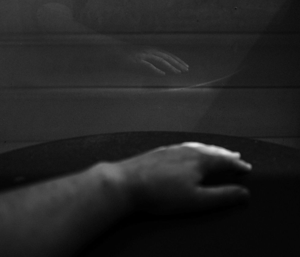 a black and white image of a hand reflected back