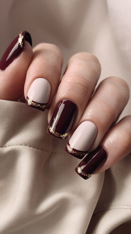 Romantisches Nageldesign: Bordeauxrote Nägel mit French-Tips in zartem Rosa und funkelndem Glitzer.