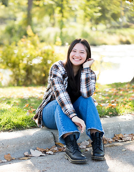 Beautiful outdoor senior picture at Tenney Park in Madison, WI featuring green grass, water, and a natural pose