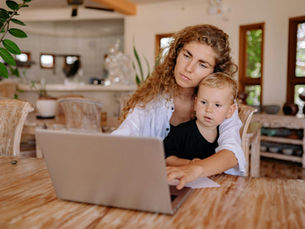 Working from home: A mother multitasks as she balances her remote work and spending quality time with her child.