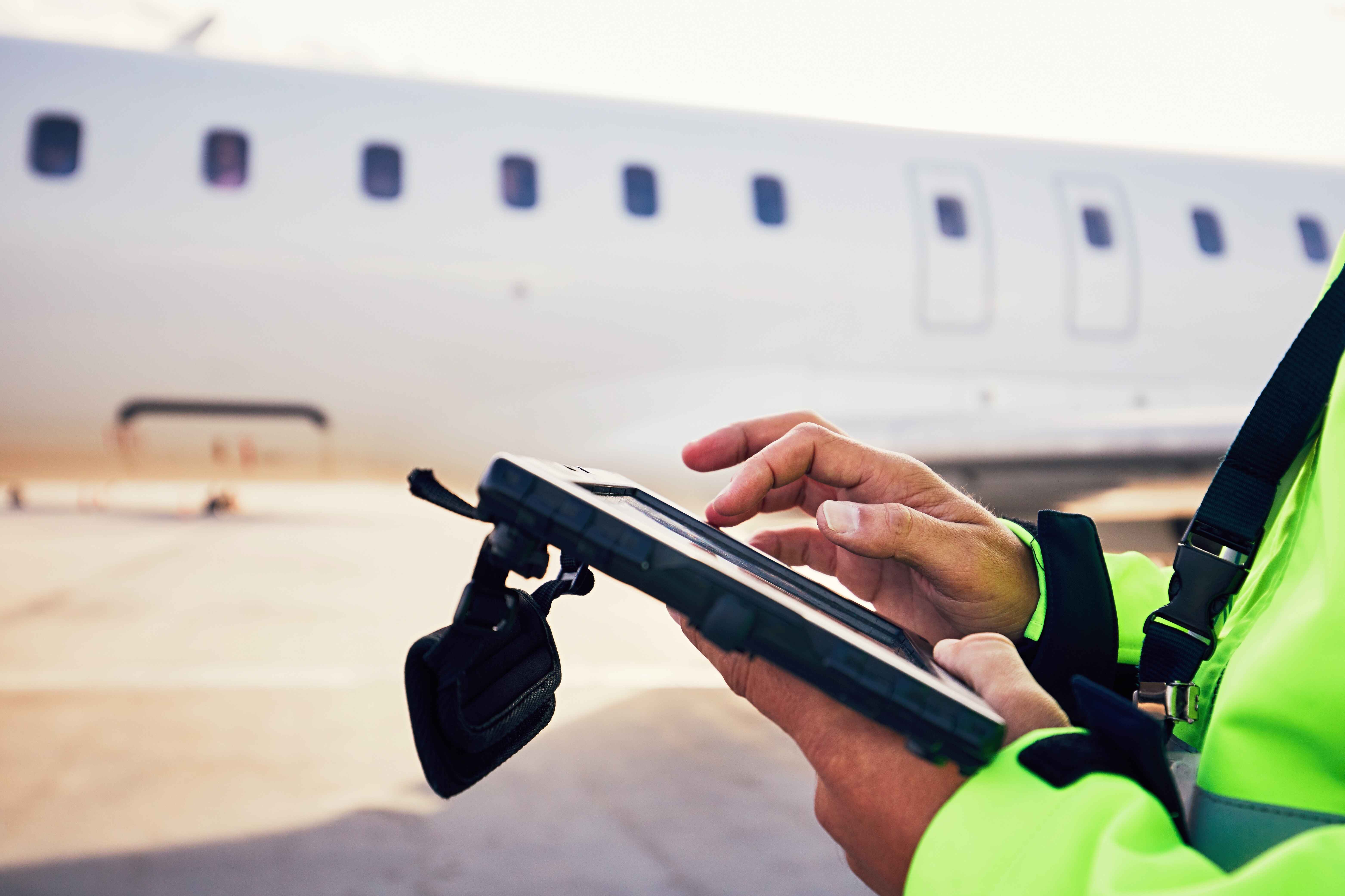 Aviation mechanic reaching into tool box, within an airplane hangar.