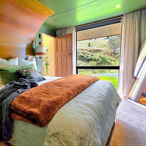 Warm handcrafted bedroom inside Cascade Cabin at Ripples Retreat”