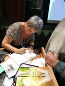 Paula Johnson author, signing books at her book launch of Silent Warrior Transformation