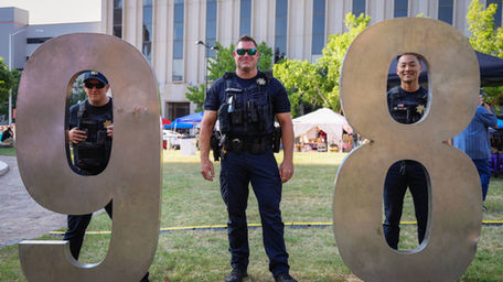 Three Tulsa Police Officers lined up to make up a "918."