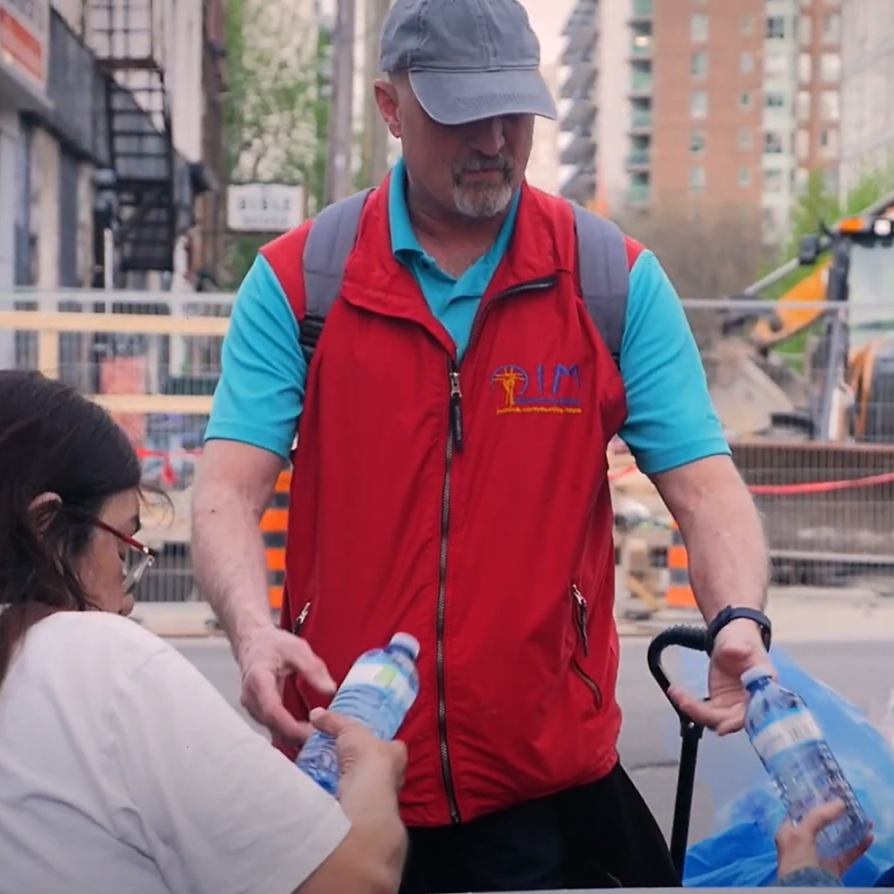 A picture of an OIM volunteer giving water to street friends.
