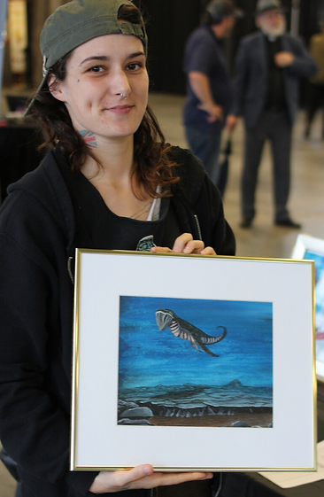 A youth from Innercity Arts smiling with her painting