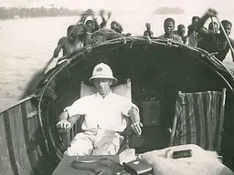 A Luxembourg colonial administrator is ferried by Congolese paddlers in the 1930s