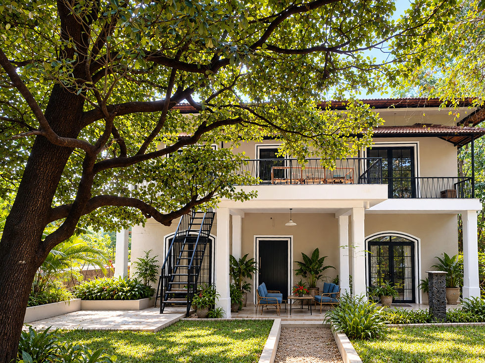 Tropical house with large tree and green lawn in front.