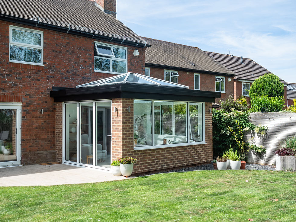 Modern brick sunroom extension with glass roof and patio