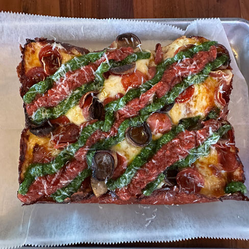Loving Cups pizza with pesto and red sauce from sams square pie in Indianapolis