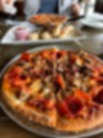 close up photo of pizza with pepperoni, sausage, bacon, and meatballs