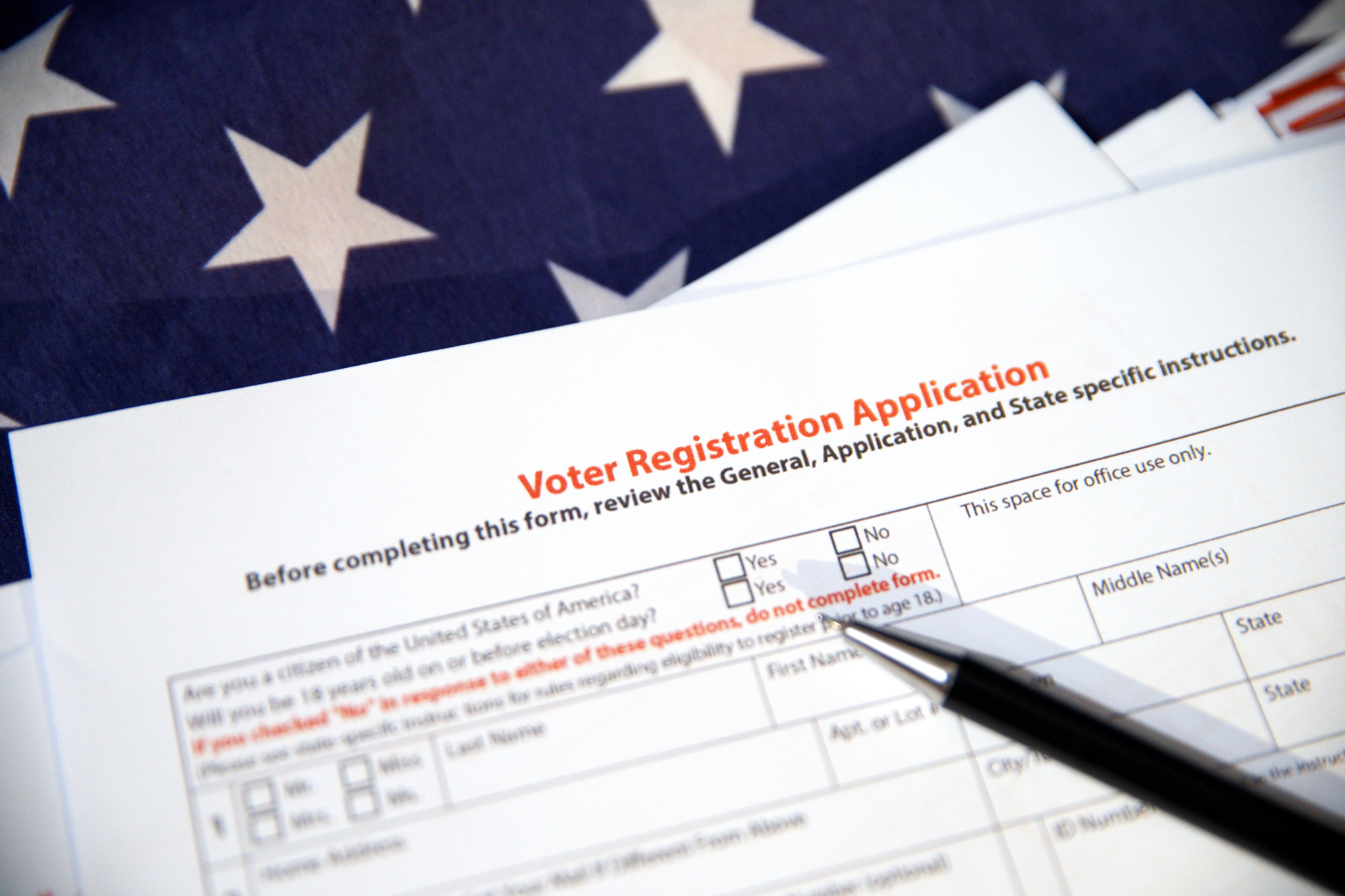 Voter registration application form with USA flag in the backdrop. American election conce