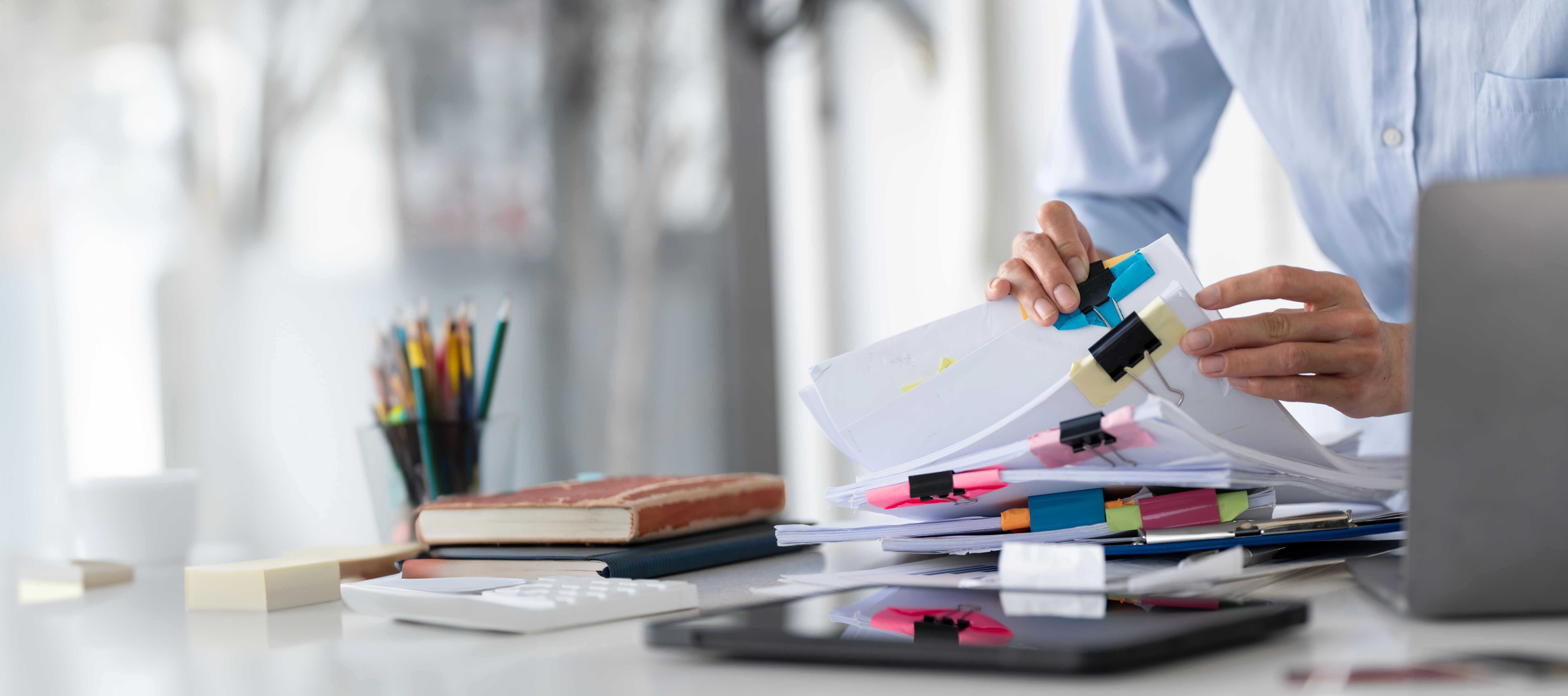 Businesswoman hands working in Stacks of paper files for searching and checking unfinished