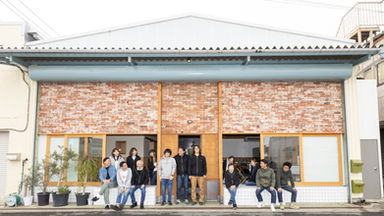 事務所前で笑顔の社員集合写真