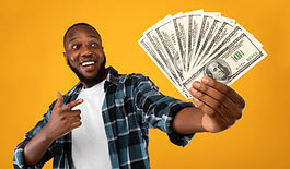 Happy Black Man Holding Money Cash Pointing Finger At Dollar Banknotes In His Hand Standin