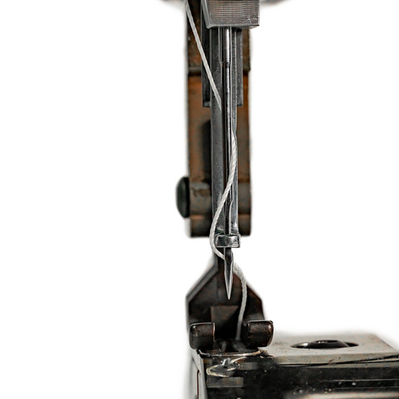 Close-up of a sewing machine needle with thread; Tippmann Industrial.