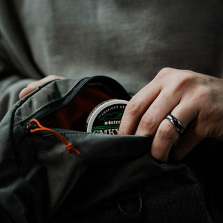 Man's hand reaching into pocket, retrieving Smokey Mountain wintergreen.