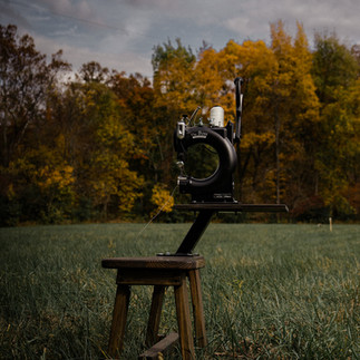 Black camera on a wooden stool in a vibrant autumn field, Mbogo Media