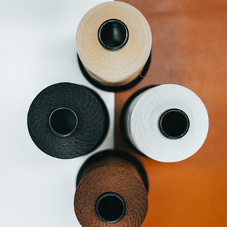 Four spools of thread arranged on white and brown background Mbogo Media