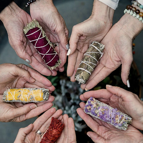 women holding smudge bundles in a circle (identity reclamation)