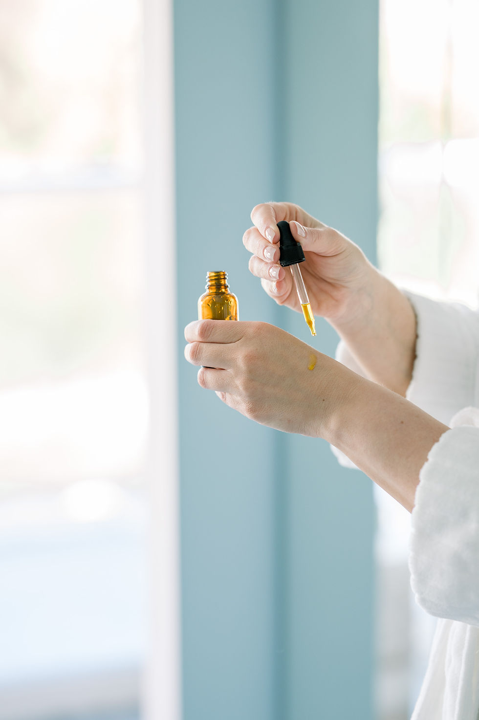 applying body oil with a dropper for self-care and Ayurvedic abhyanga practice during spring cleanse