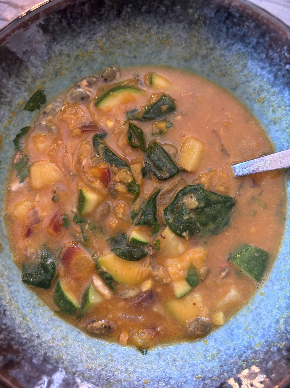 Homemade lentil and vegetable soup with zucchini, greens, pumpkin seeds, and lemon tahini, prepared as a grounding Ayurvedic winter meal.