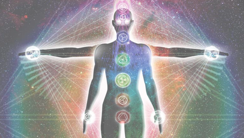 Silhouette of a human figure with chakras illuminated along the body's centerline, arms gently extended outward. Surrounding the figure is a vibrant cosmic background with radiant energy lines, symbolizing the flow and connection of the energy field and subtle body systems