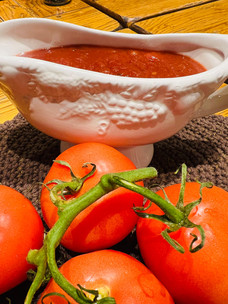 vine tomatoes near a gravy boat of ketchup