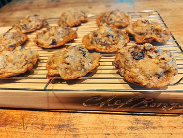 Freshly baked Chef Bongo's Rustic Chocolate Pecan Cookies cooling on a wire rack, with visible chocolate chips and pecan pieces, placed on a wooden surface with 'Chef Bongo' branding.