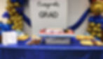 Graduation party setup with 'Congrats GRAD' banner, cake, snacks