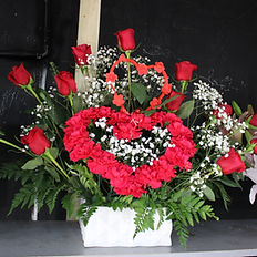 Heart-shaped red carnation and rose floral arrangement