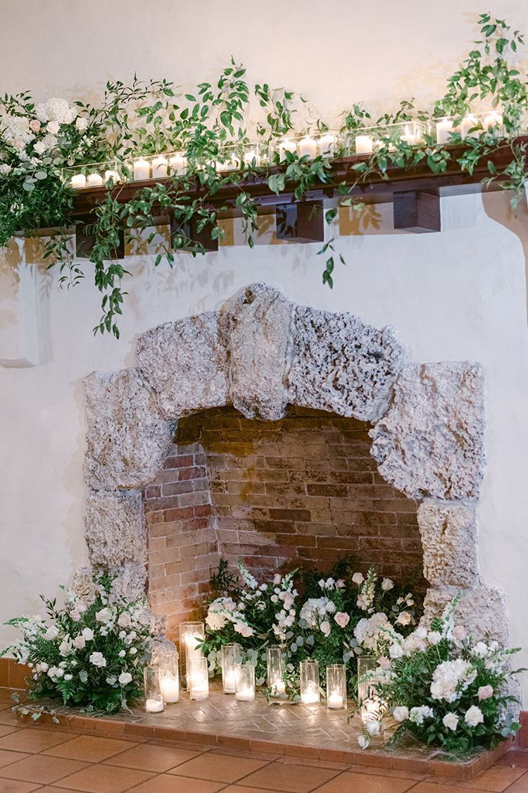 Stunning fireplace laced with greenery & candlelight