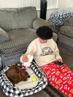Boy sitting on the floor with his puppy.