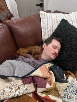 Man and puppy sleeping on the couch