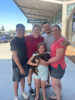 Family picking up their puppy from the Airport