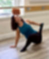 Woman stretching. Turquoise top, black leggings, wooden floor, and barre. Fluid Power Barre Fitness.