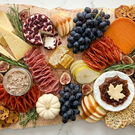 A luxury fall charcuterie spread on a curly maple charcuterie board.