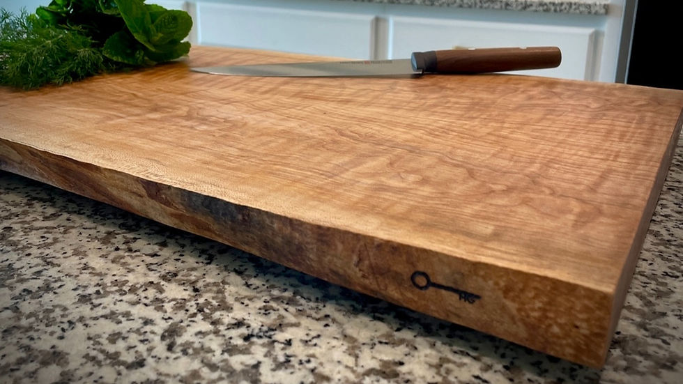 The Live Board, a live-edge curly maple charcuterie board on a kitchen counter.