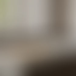 A luxury Japandi kitchen featuring a bold-veined marble waterfall island and dark wood cabinetry, showcasing a handcrafted live-edge charcuterie board by Key Home Goods as a functional art centerpiece.