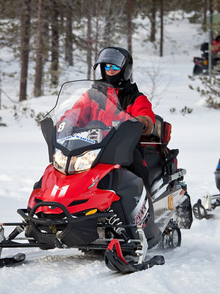 Enjoy snowmobile ride in snow during your winter holidays in Finland