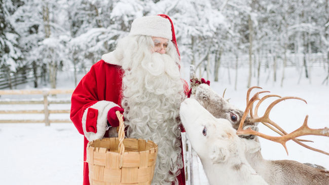 Santa Claus with reindeer in Winter Wonderland in Lapland