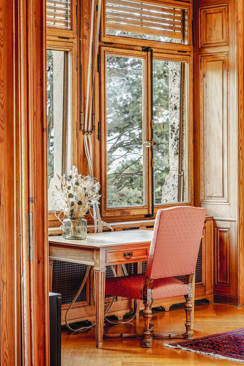 fauteuil rose devant une fenêtre