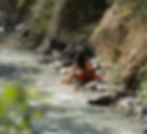 Pieds dans l'eau, sur un caillou, rivière, femme en orange