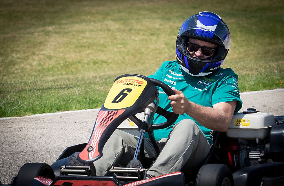 Pilot de kart amb casc blau i ulleres, a pista a l'aire lliure, maneja un kart número 6 sota el sol.