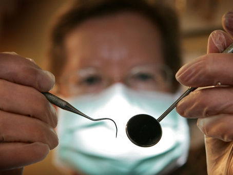 Dentista revisando la boca de un paciente