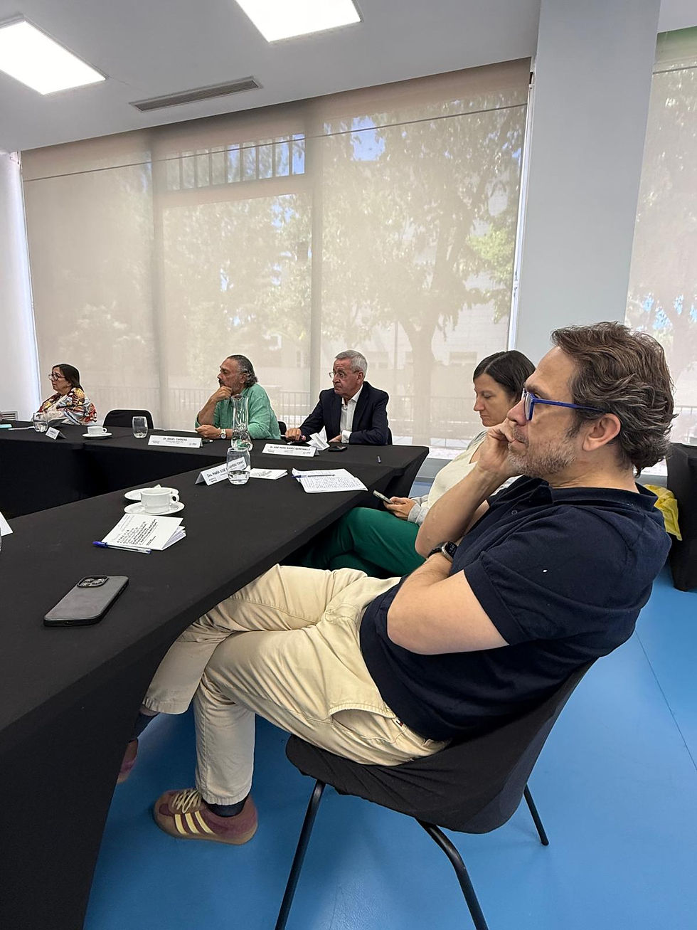 Participantes en un curso sentados alrededor de una mesa cuadrada