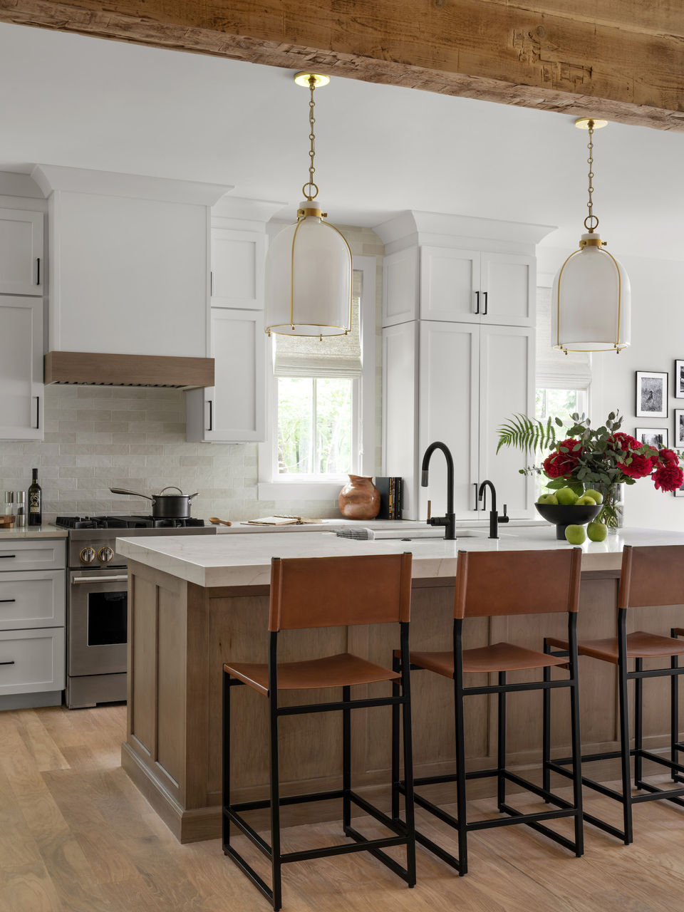 Modern kitchen with white cabinetry, light wood island, pendant lights, and tall tan chairs. Palmer Kay Design_Interior Design_Peachtree City, GA