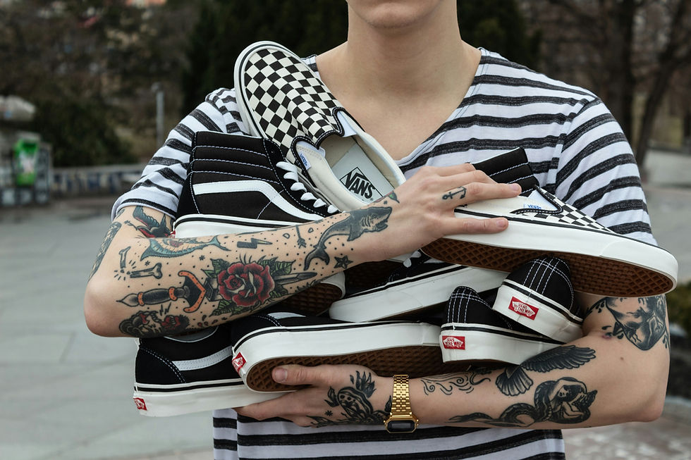 Tattooed person holding trainers