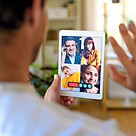 Man at home attending a Spanish conversation group class through his tablet.